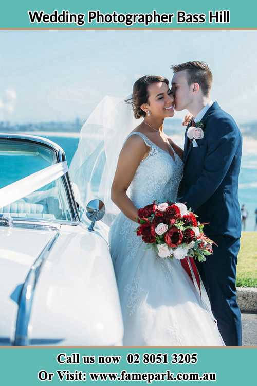 Photo of the Groom kiss the Bride besides the bridal car Bass Hill NSW 2197