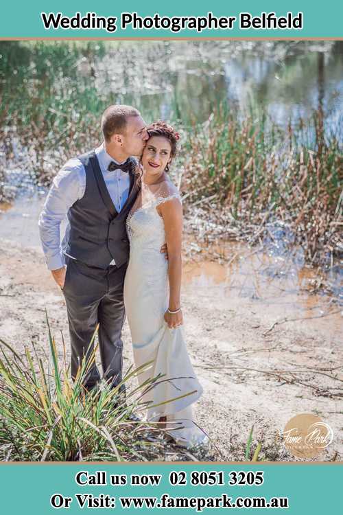 Photo of the Groom kiss the Bride near the lake Belfield NSW 2191