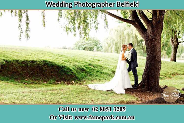 Photo of the Bride and the Groom kissing under the tree Belfield NSW 2191