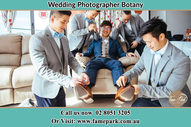 Photo of the Groom helping by the groomsmen getting ready Botany NSW 2019