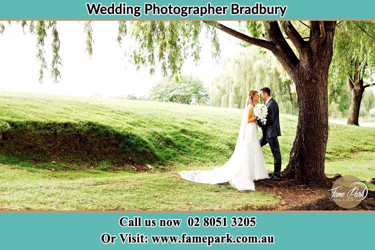 Photo of the Bride and the Groom kissing under the tree Bradbury NSW 2560