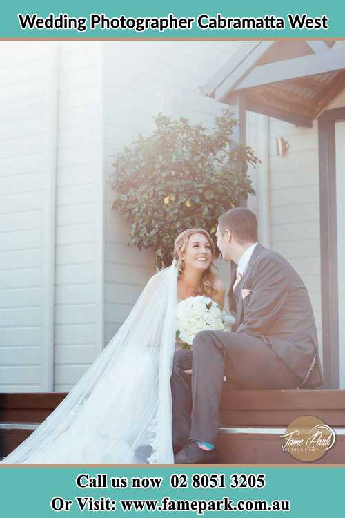 Photo of the Bride and the Groom looking each other while sitting at the staircase Cabramatta West NSW 2166