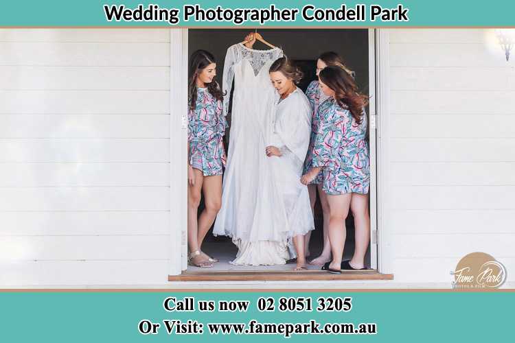 Photo of the Bride and the bridesmaids checking the wedding gown at the door Condell Park NSW 2200