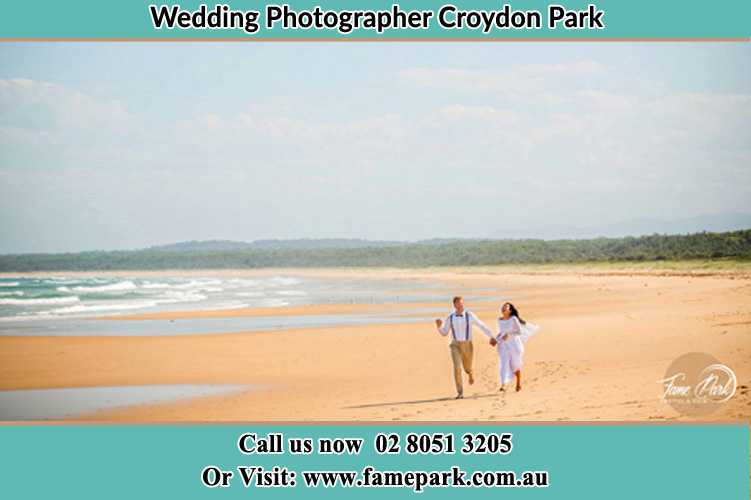 Photo of the Groom and the Bride walking at the sea shore Croydon Park NSW 2133