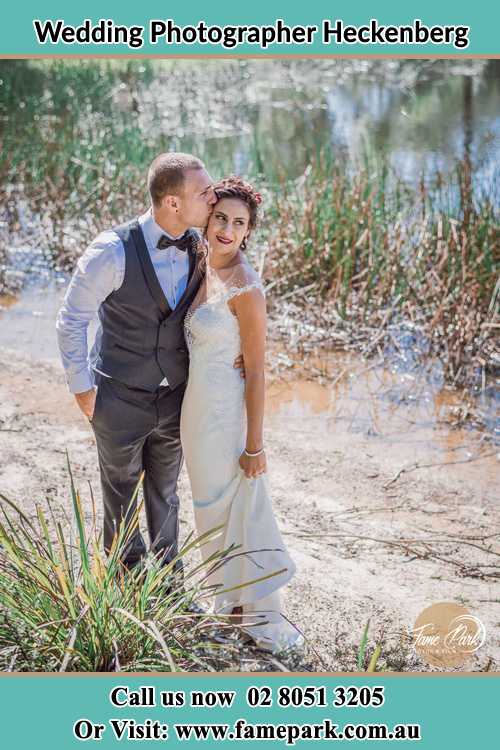 Photo of the Groom kiss the Bride near the lake Heckenberg NSW 2168