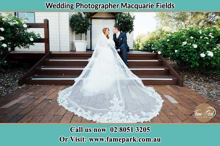 Photo of the Bride and the Groom looking each other while sitting at the staircase Macquarie Fields NSW 2564