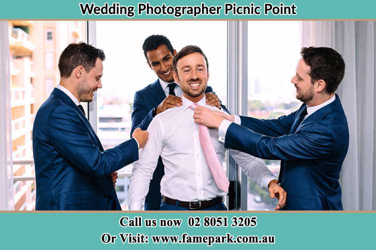 Photo of the Groom helping by the groomsmen getting ready Picnic Point NSW 2213