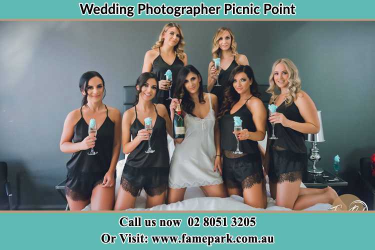 Photo of the Bride and the bridesmaids wearing lingerie and holding glass of wine on bed Picnic Point NSW 2213