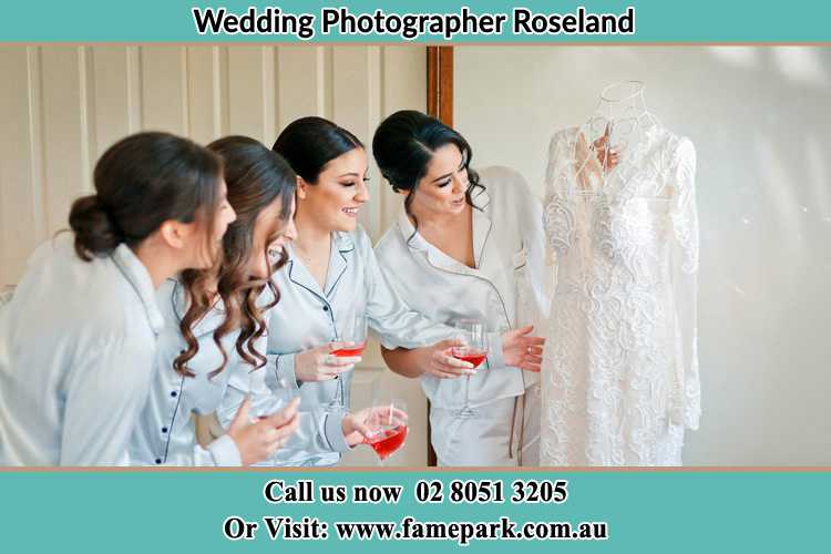 Photo of the Bride and the bridesmaids looking at the wedding gown Roseland NSW 2196