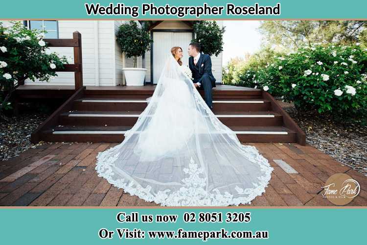 Photo of the Bride and the Groom looking each other while sitting at the staircase Roseland NSW 2196