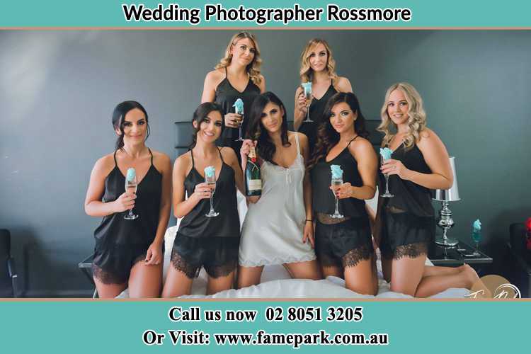 Photo of the Bride and the bridesmaids wearing lingerie and holding glass of wine on bed Rossmore NSW 2557