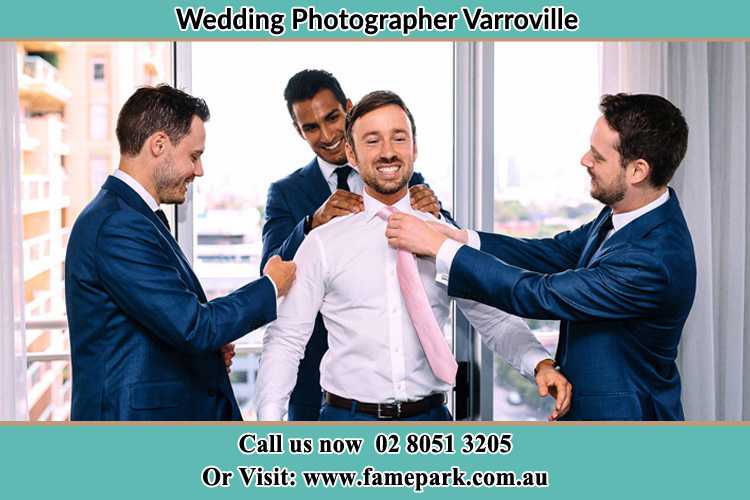 Photo of the Groom helping by the groomsmen getting ready Varroville NSW 2566