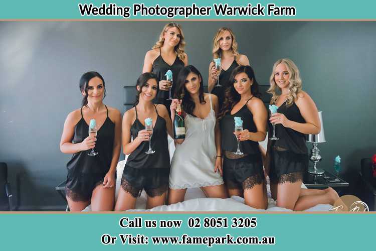 Photo of the Bride and the bridesmaids wearing lingerie and holding glass of wine on bed Warwick Farm NSW 2170