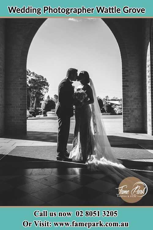 Photo of the Groom and the Bride kissing at the front of the church Wattle Grove NSW 2713